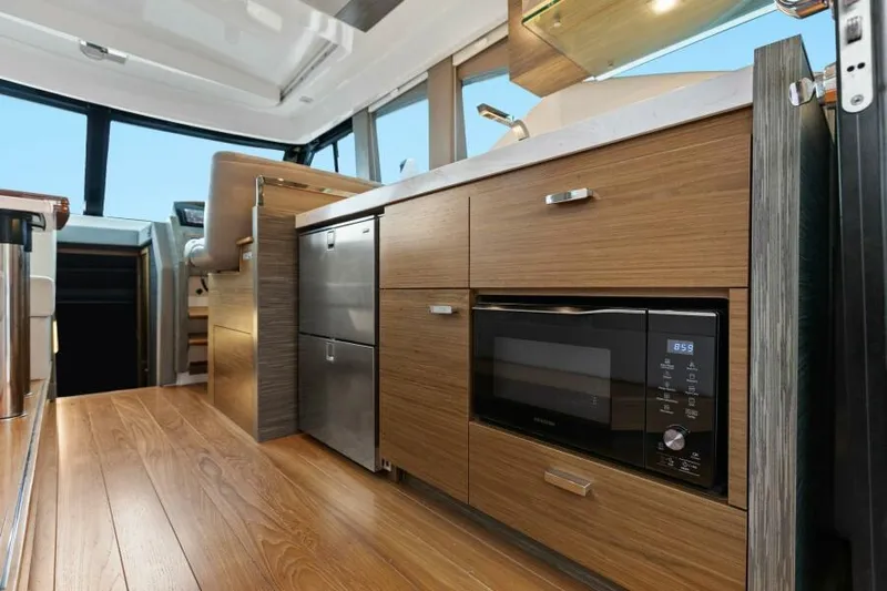 Big Eyes Yacht Photos Pics Modern kitchen interior of 2019 Tiara Yachts 39 Coupe with wood cabinetry and appliances.
