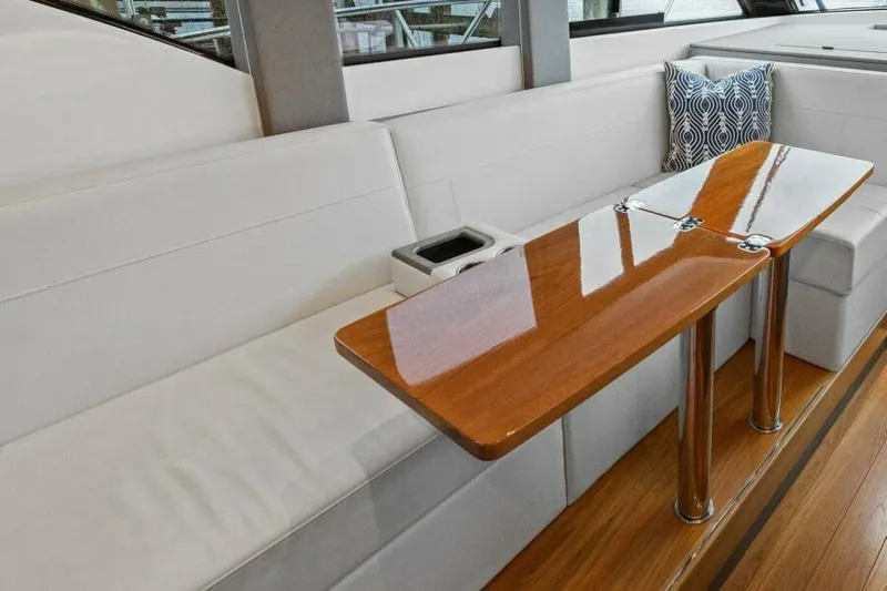 Big Eyes Yacht Photos Pics Interior of 2019 Tiara Yachts 39 Coupe with sleek wooden table and white seating.