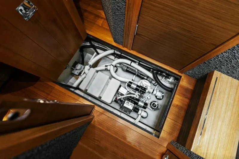 Big Eyes Yacht Photos Pics Engine compartment of 2019 Tiara Yachts 39 Coupe, showcasing mechanical components and piping.