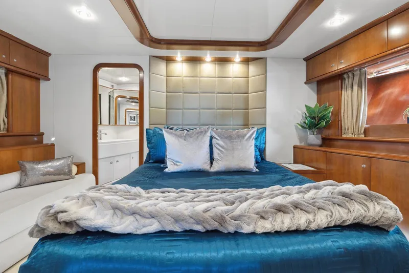 Alchemy Yacht Photos Pics Luxurious bedroom interior of 2003 Baia PANTHER 80 yacht with elegant decor and plush bedding.