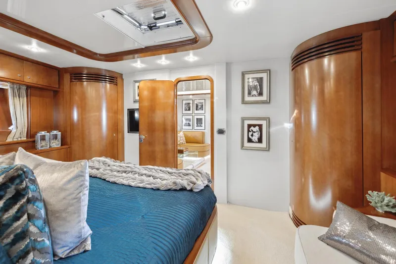 Alchemy Yacht Photos Pics Luxurious 2003 Baia Panther 80 yacht bedroom with elegant wood finishes and modern decor.