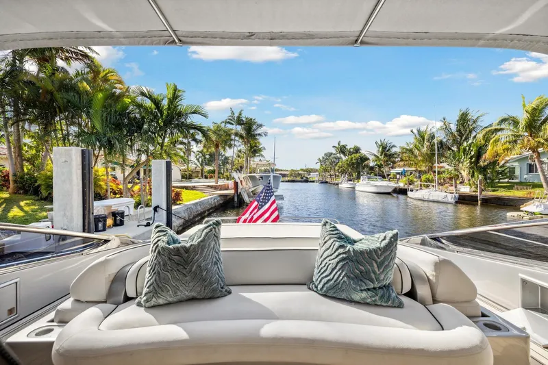 Alchemy Yacht Photos Pics Luxurious 2003 Baia PANTHER 80 yacht with plush seating, docked in a tropical canal.