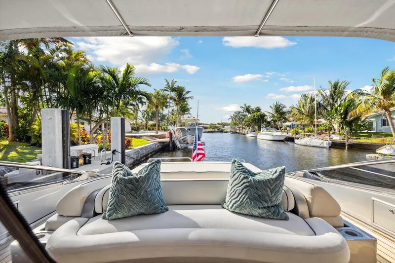 Alchemy Yacht Photos Pics 2003 Baia PANTHER 80 yacht with plush seating, docked by a scenic canal.