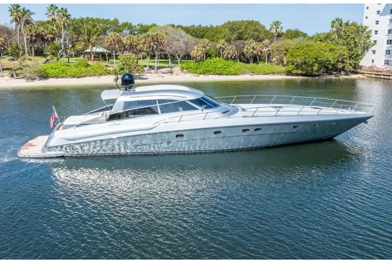 Alchemy Yacht Photos Pics Luxury 2003 Baia Panther 80 yacht cruising near lush shoreline.