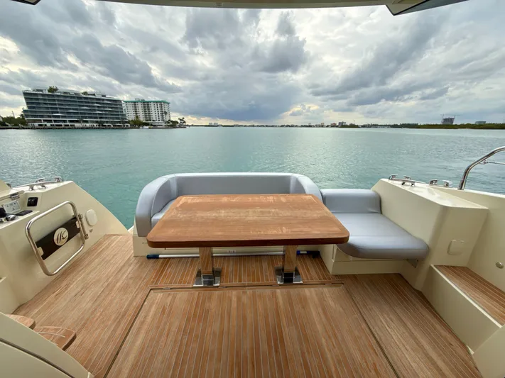  Yacht Photos Pics 2017 Beneteau Monte Carlo 5S yacht deck with seating, overlooking calm waters and modern buildings.