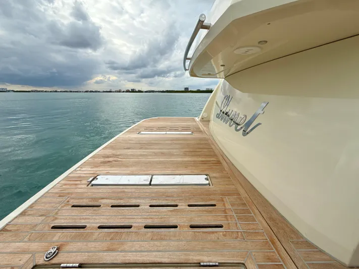  Yacht Photos Pics 2017 Beneteau Monte Carlo 5S yacht with wooden deck, overlooking calm waters and cloudy sky.