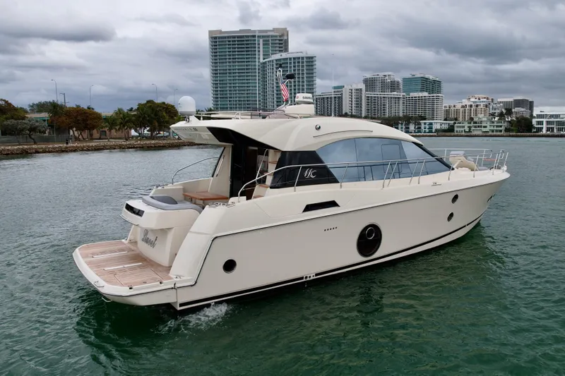  Yacht Photos Pics 2017 Beneteau Monte Carlo 5S yacht cruising near urban waterfront under cloudy skies.