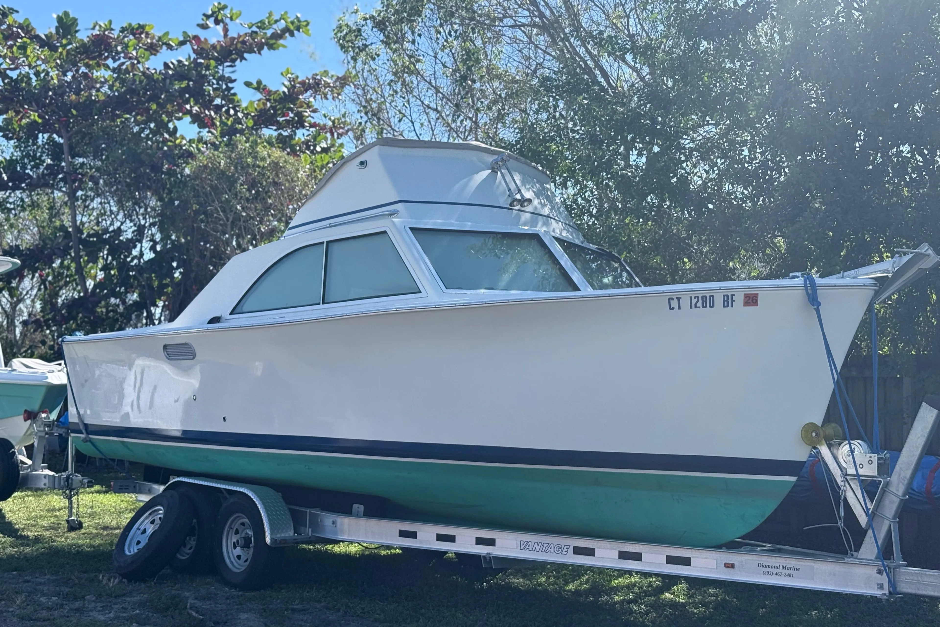 1969 Custom Alglas Saint John 25 ft. Sportfisher on trailer, parked outdoors.