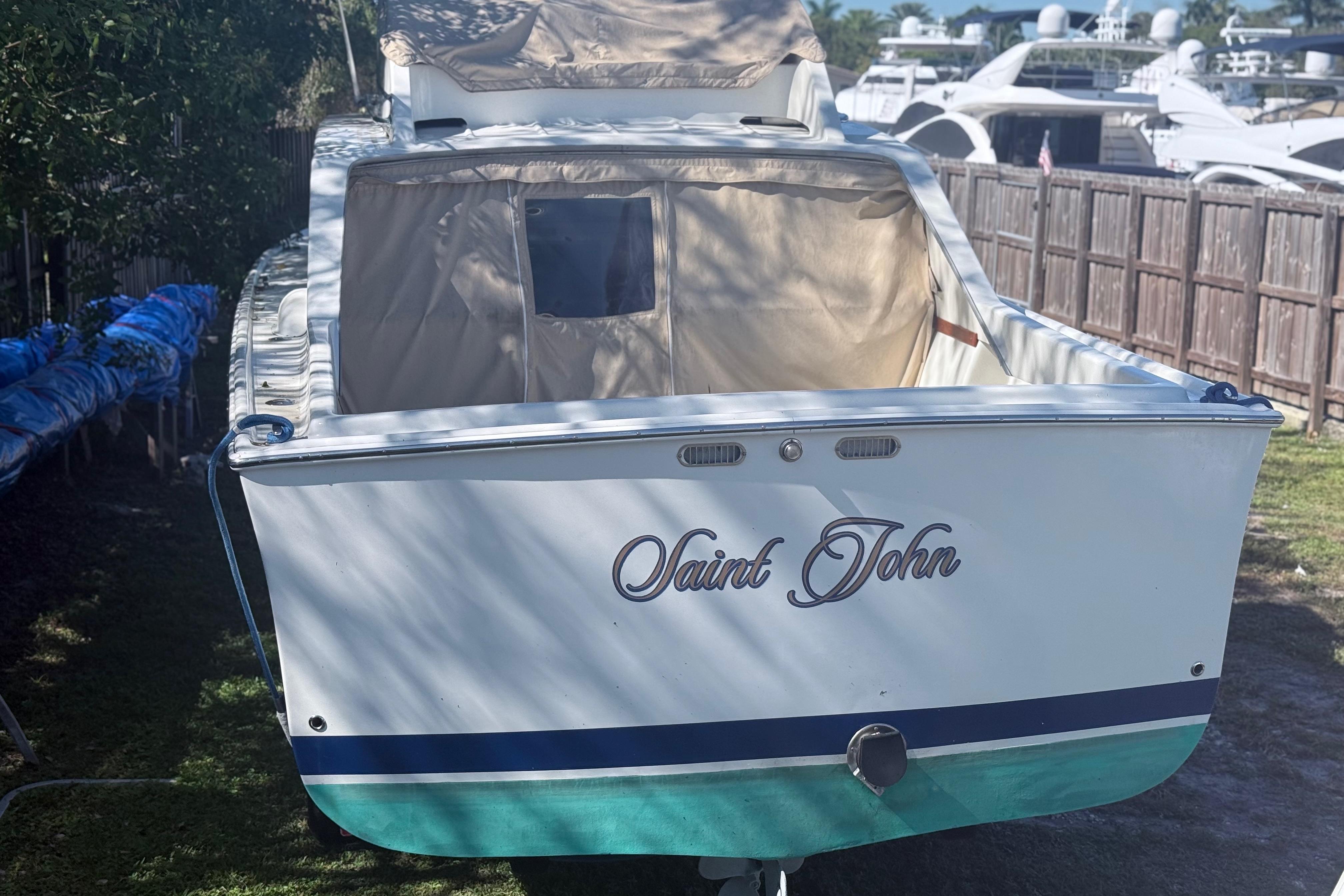 1969 Custom Alglas Saint John 25 ft. Sportfisher boat, docked outdoors, rear view.