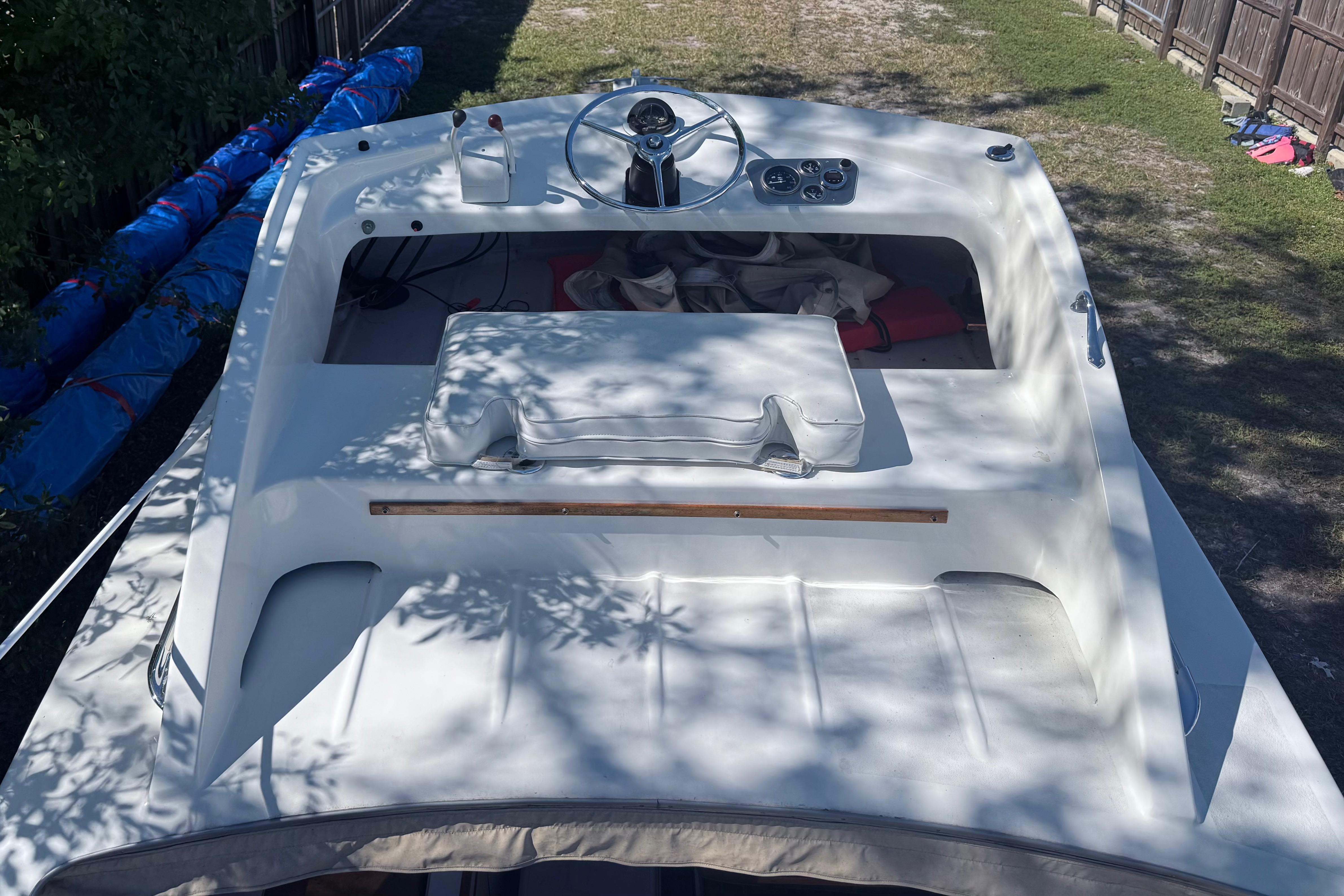 1969 Custom Alglas Saint John 25 ft. Sportfisher boat, top view, white deck, outdoor setting.