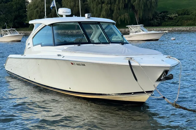  Yacht Photos Pics 2021 Pursuit DC 326 Dual Console boat anchored on calm water.