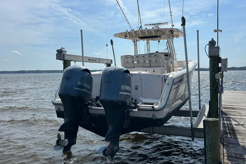  Yacht Photos Pics 2008 Grady-White Canyon 336 boat with twin Yamaha engines on a lift by the dock.