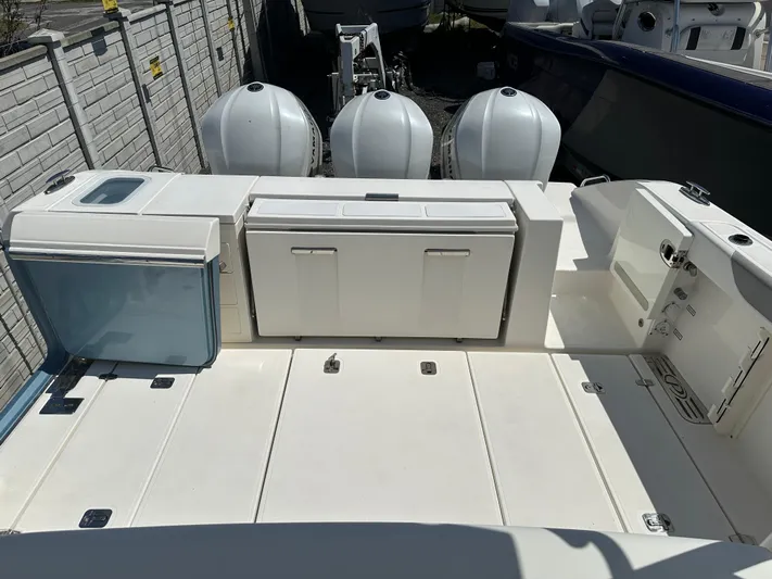  Yacht Photos Pics 2020 Pursuit S368 boat deck with storage compartments and triple outboard engines.