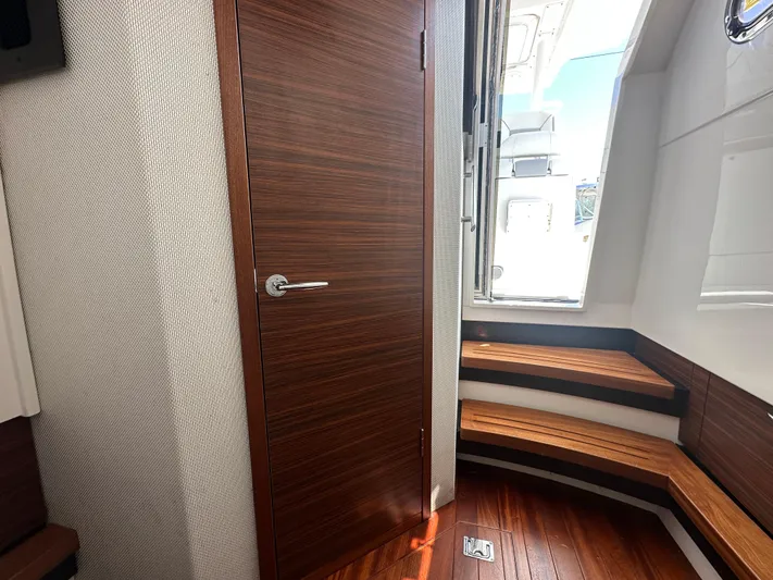 Yacht Photos Pics Interior of 2020 Pursuit S368 boat with wooden door and seating area.