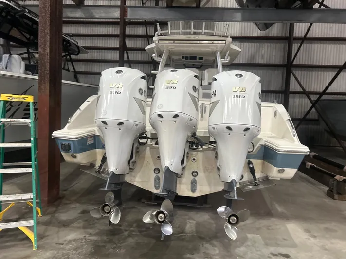  Yacht Photos Pics 2020 Pursuit S368 boat with triple outboard engines in a storage facility.
