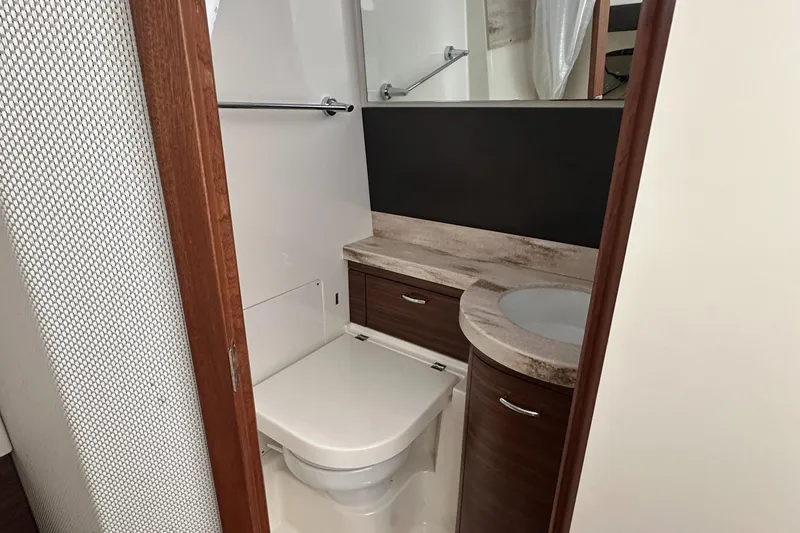  Yacht Photos Pics 2020 Pursuit S368 boat bathroom with modern fixtures and wood accents.