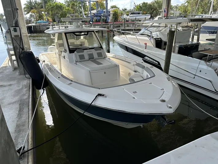  Yacht Photos Pics 2020 Pursuit S368 boat docked at marina, featuring sleek design and spacious seating.