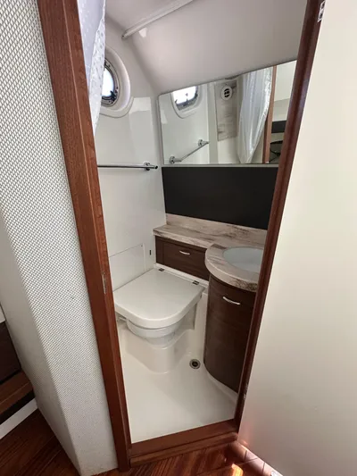  Yacht Photos Pics 2020 Pursuit S368 boat bathroom with modern fixtures and wood accents.
