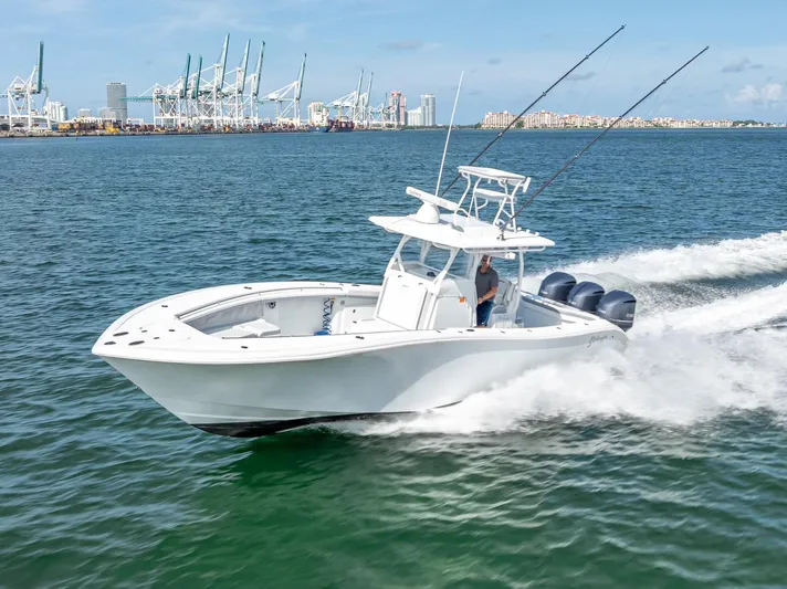  Yacht Photos Pics 2021 Yellowfin 34 boat cruising on water near industrial port.