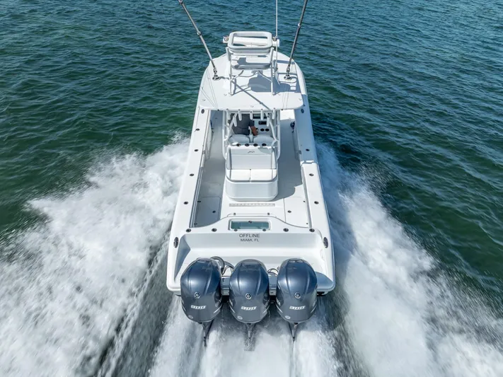  Yacht Photos Pics 2021 Yellowfin 34 boat cruising on water with triple outboard engines.