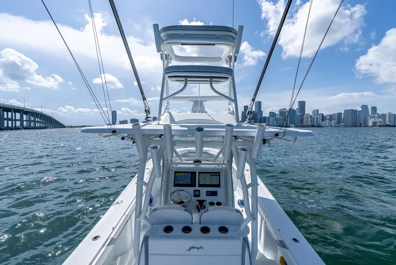  Yacht Photos Pics 2021 Yellowfin 34 boat navigating near city skyline and bridge on a sunny day.