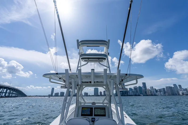 Yacht Photos Pics 2021 Yellowfin 34 boat cruising near city skyline under sunny blue sky.