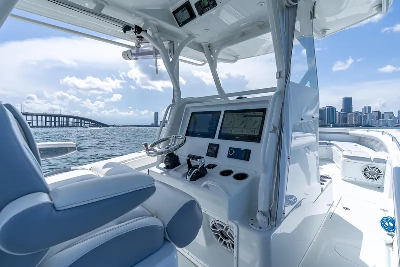  Yacht Photos Pics 2021 Yellowfin 34 boat interior with modern dashboard, city skyline, and bridge in background.