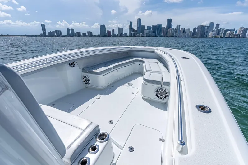  Yacht Photos Pics 2021 Yellowfin 34 boat with spacious seating, ocean view, and city skyline in the background.