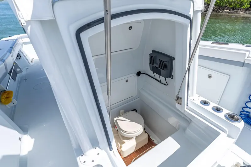  Yacht Photos Pics 2021 Yellowfin 34 boat interior with compact marine toilet and storage area.