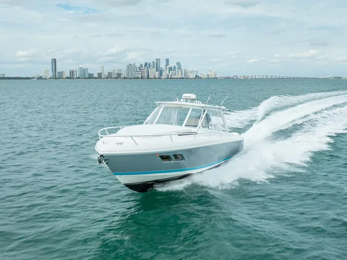  Yacht Photos Pics 2015 Intrepid 400 Cuddy cruising on open water with city skyline in background.