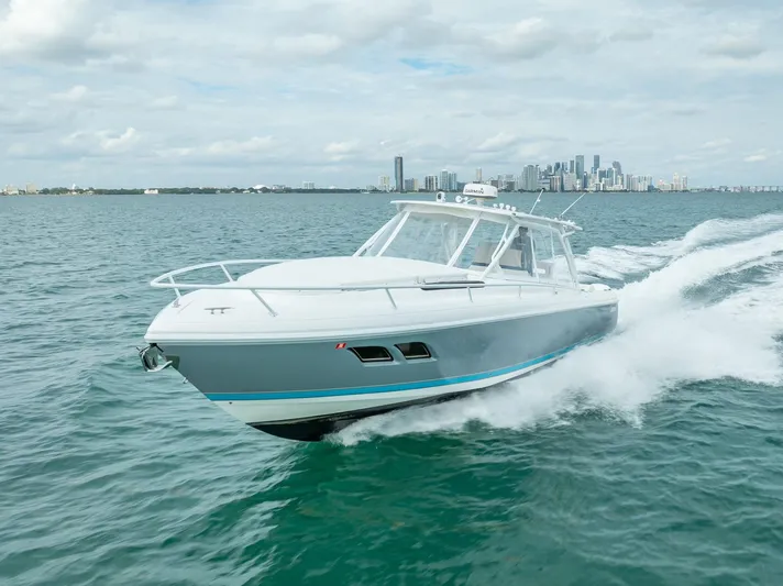  Yacht Photos Pics 2015 Intrepid 400 Cuddy cruising on open water with city skyline in background.
