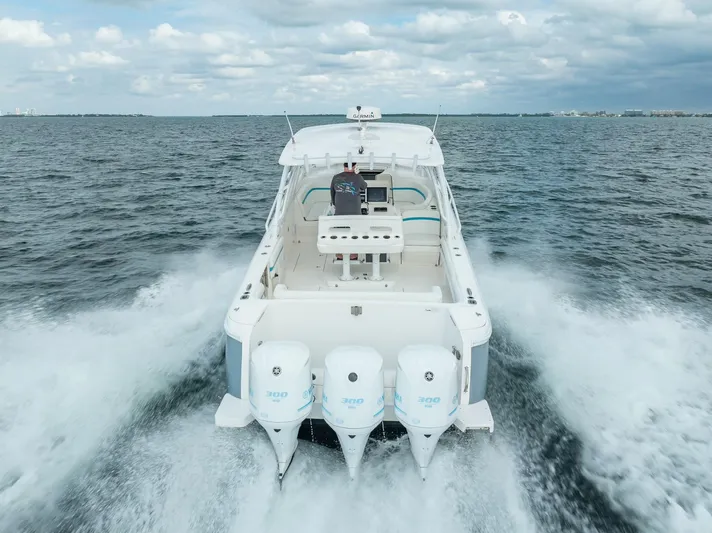  Yacht Photos Pics 2015 Intrepid 400 Cuddy cruising on open water, rear view with triple outboard engines.