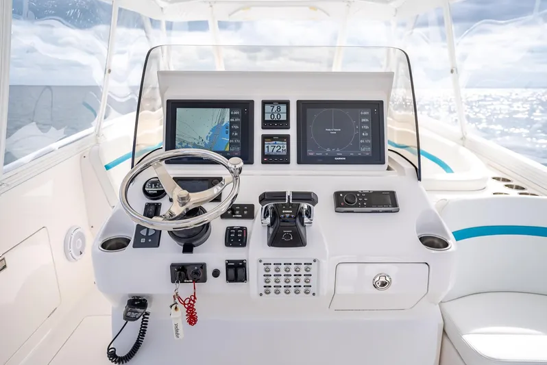  Yacht Photos Pics Control panel of a 2015 Intrepid 400 Cuddy boat with navigation screens and steering wheel.
