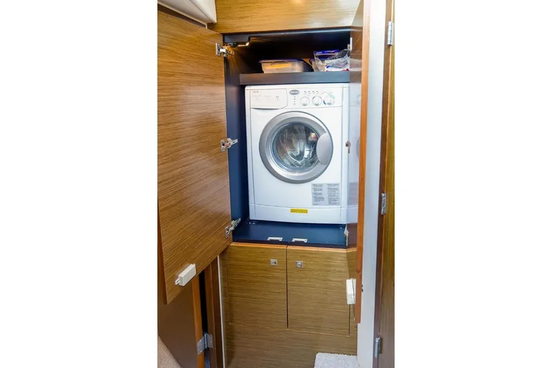  Yacht Photos Pics Laundry area with washer in 2016 Cruisers Yachts 45 Cantius, wooden cabinetry.