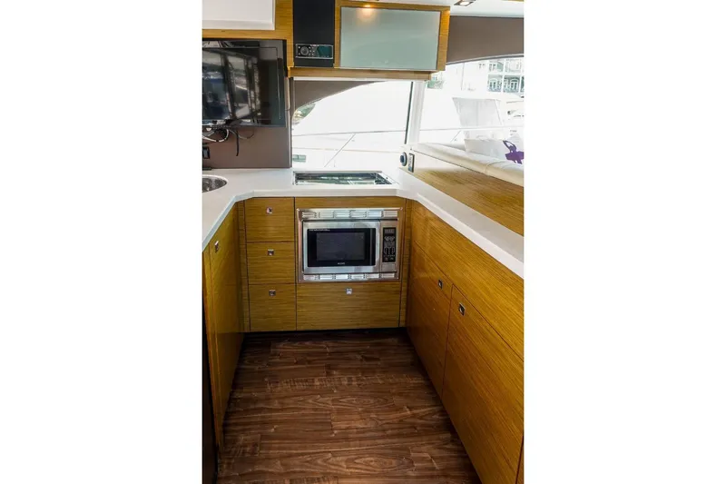  Yacht Photos Pics Modern kitchen interior of 2016 Cruisers Yachts 45 Cantius with wood cabinetry and appliances.