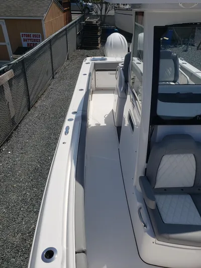  Yacht Photos Pics 2023 Everglades 285CC boat, sleek white deck, modern seating, outdoor setting.