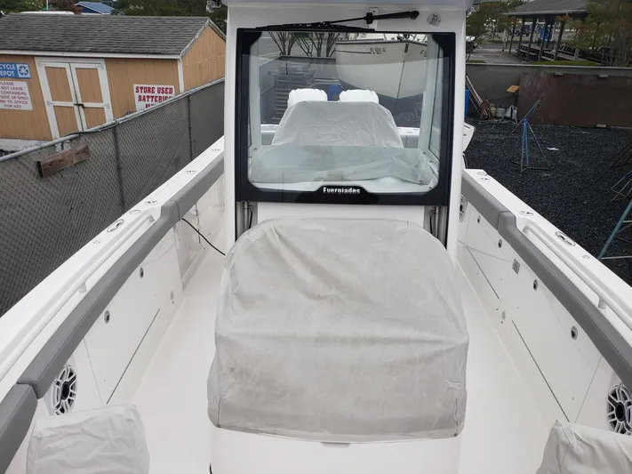  Yacht Photos Pics 2023 Everglades 285CC boat interior with covered seating and console, docked outdoors.