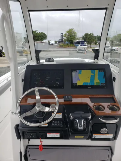  Yacht Photos Pics 2023 Everglades 285CC boat dashboard with navigation screens and steering wheel.