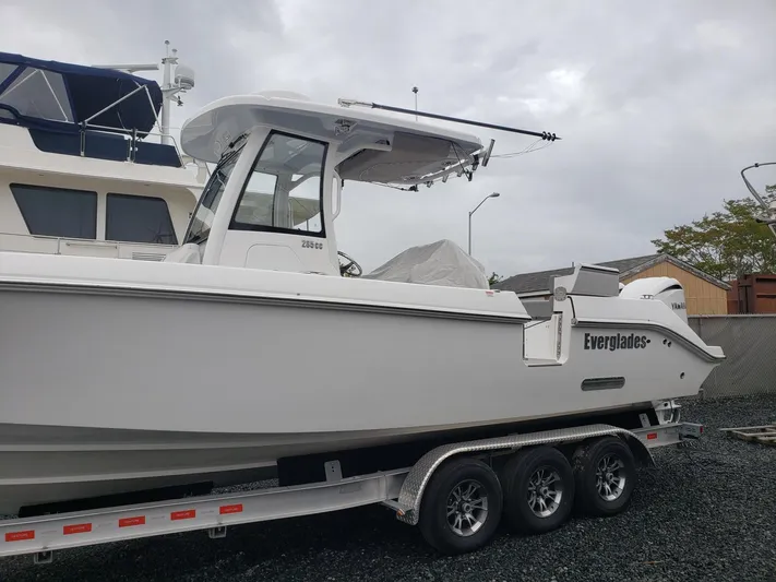  Yacht Photos Pics 2023 Everglades 285CC boat on a trailer, parked outdoors.