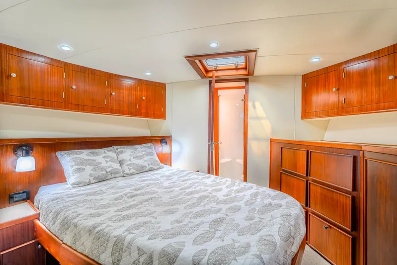 Julia G Yacht Photos Pics Luxurious bedroom interior of 1982 Hatteras 46 Convertible yacht with wood cabinetry.