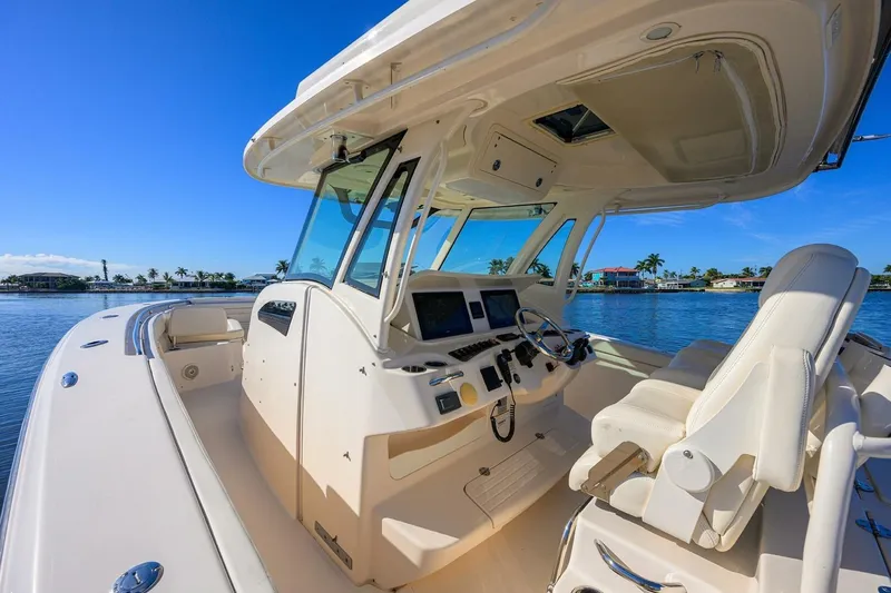  Yacht Photos Pics 2018 Grady-White Canyon 376 boat interior with helm, seats, and clear blue sky.
