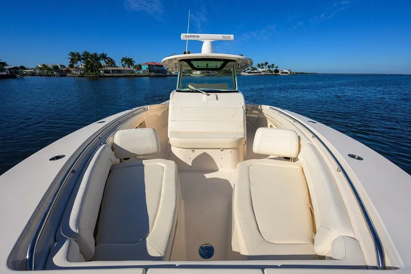  Yacht Photos Pics 2018 Grady-White Canyon 376 boat on calm water, featuring spacious seating and clear blue skies.