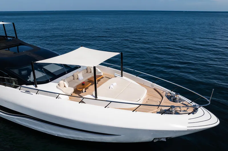  Yacht Photos Pics Luxury 2023 Mangusta 104 REV yacht on open sea, featuring sleek design and sunshade.