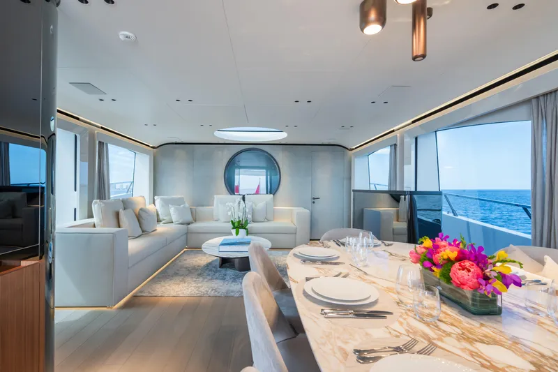  Yacht Photos Pics Luxurious interior of 2023 Mangusta 104 REV yacht with elegant dining and seating areas.