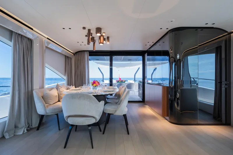  Yacht Photos Pics Luxurious interior of 2023 Mangusta 104 REV yacht with elegant dining area and ocean view.