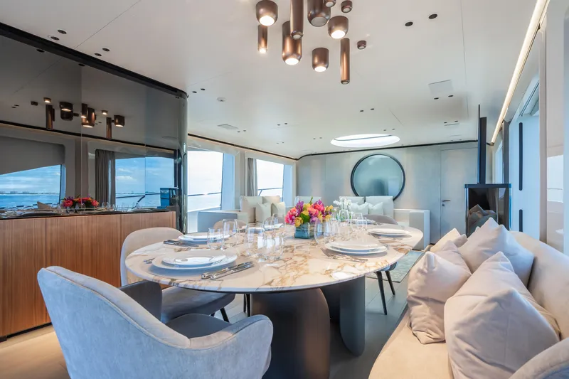  Yacht Photos Pics Luxurious dining area on 2023 Mangusta 104 REV yacht with elegant decor and panoramic views.
