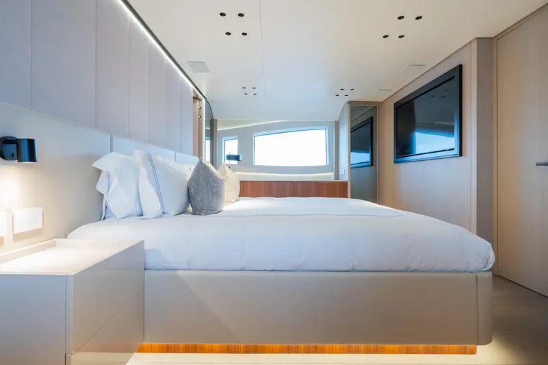  Yacht Photos Pics Luxurious bedroom interior on 2023 Mangusta 104 REV yacht, featuring modern design and elegant furnishings.