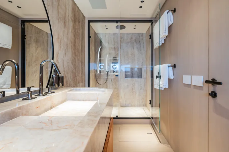  Yacht Photos Pics Luxurious bathroom in 2023 Mangusta 104 REV yacht with marble finishes and modern fixtures.