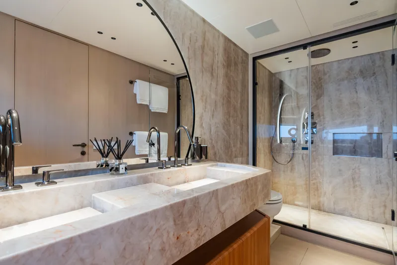  Yacht Photos Pics Luxurious bathroom in 2023 Mangusta 104 REV yacht with marble sink and glass shower.