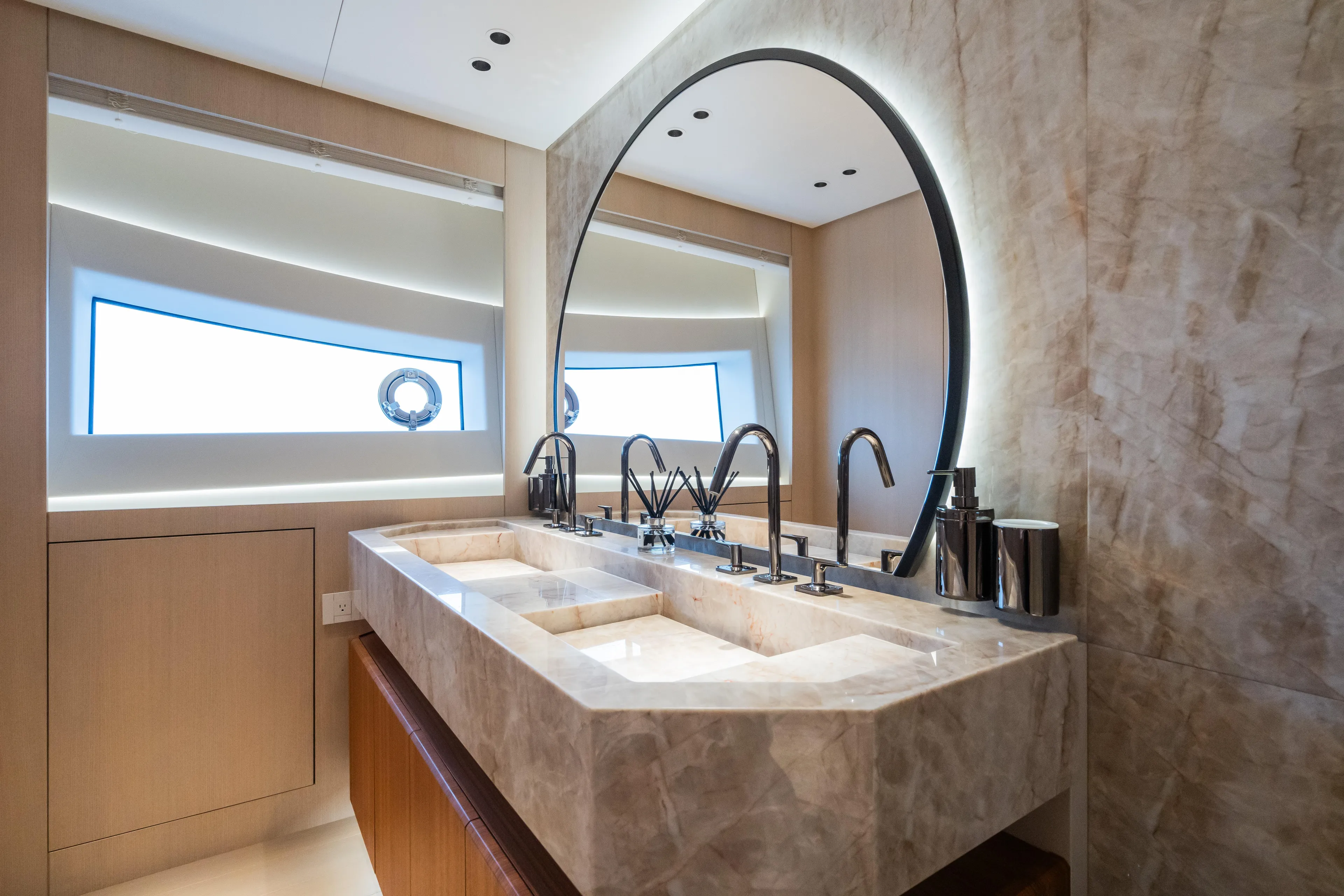  Yacht Photos Pics Luxurious bathroom in 2023 Mangusta 104 REV yacht with marble sink and round mirror.